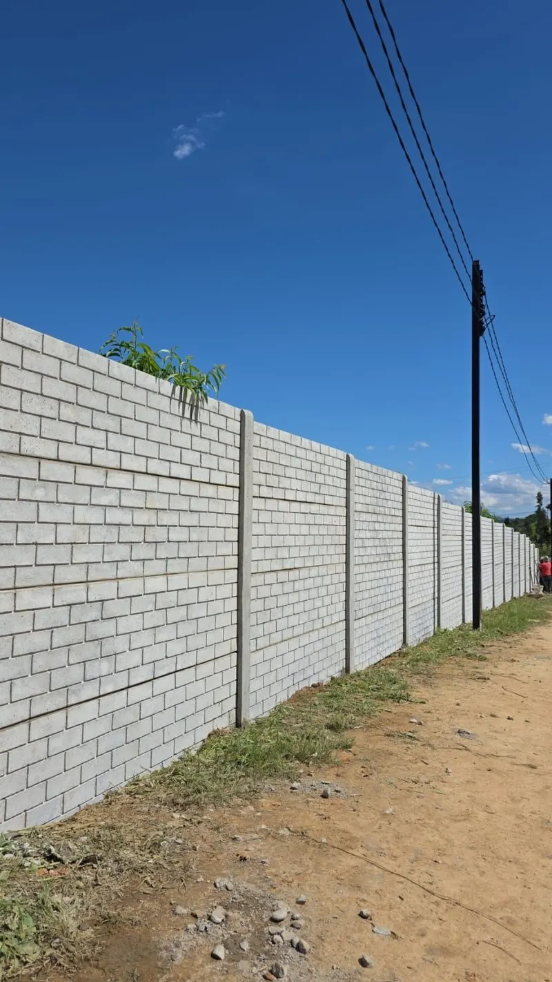 Pandereta con diseño de ladrillo junto a un camino rural